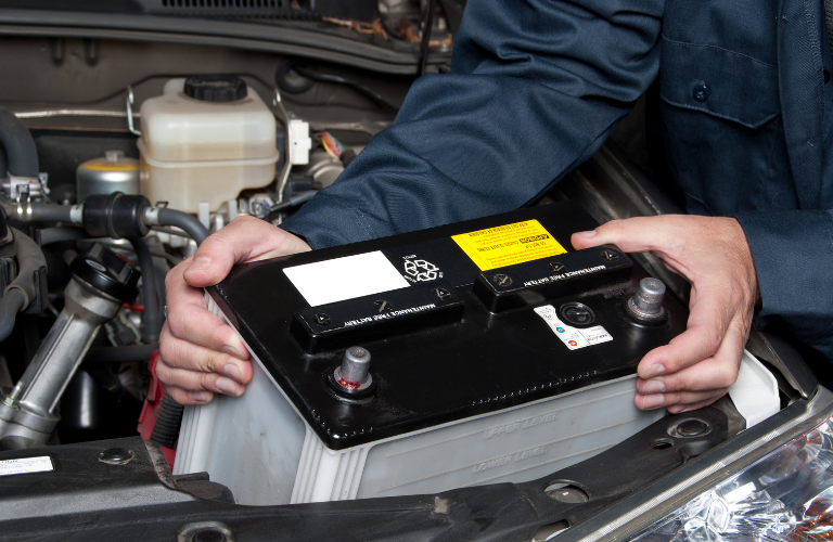 Mechanic replacing battery of a vehicle 